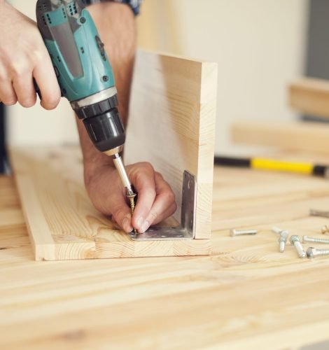 Close up of carpenter working with drill